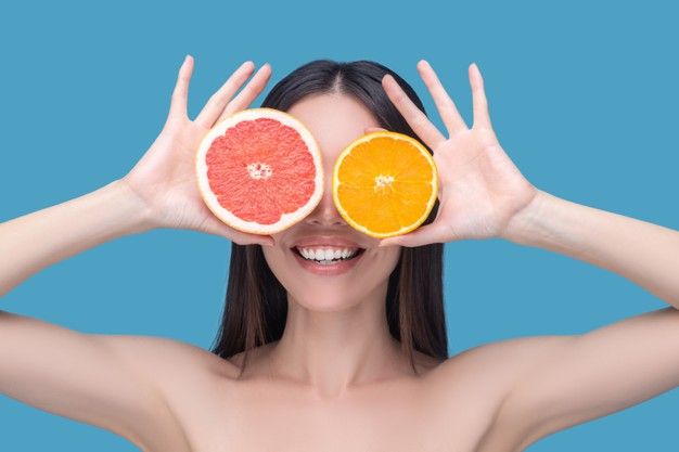 mujer con pomelo y naranja